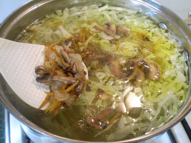 Заправьте суп жареными овощами и грибами. Проварите 10 минут.