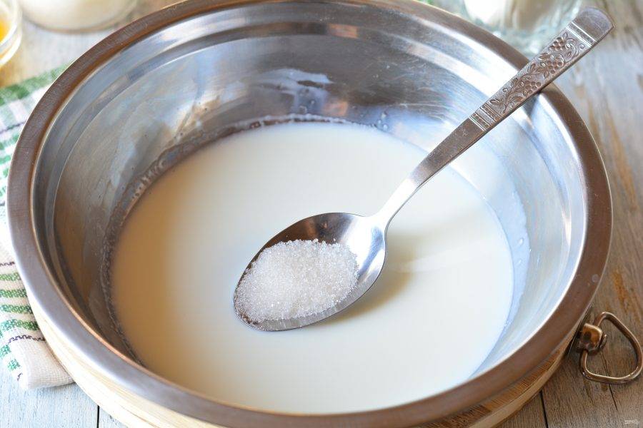 Приготовьте опару. В теплое молоко всыпьте 1 столовую ложку сахара.