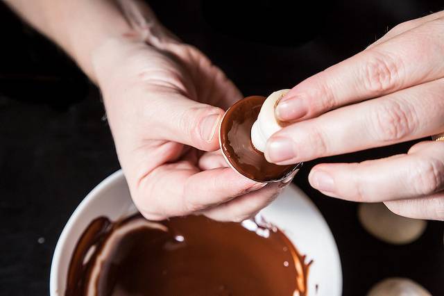 3. Шоколад растопим. Когда безе будет готово и чуть затвердеет, обрезаем верхнюю острую часть "ножек". "Шляпки" окунаем в шоколад и лепим их к "ножкам". 