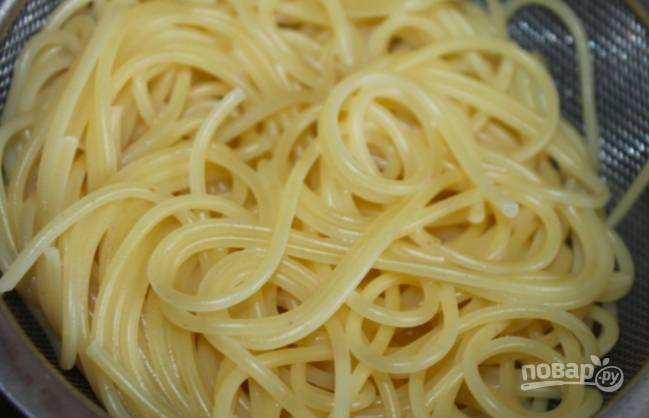 Пока варится соус, поставьте вариться спагетти по инструкции на упаковке. Затем слейте воду.