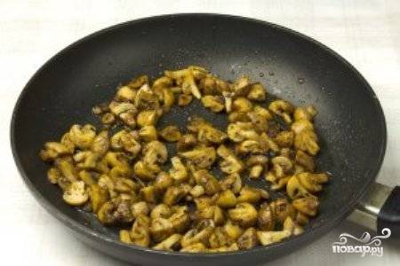 На горячую сковороду вылейте растительное масло и выложите грибы и лук. Добавьте орегано, паприку, перец и жарьте 5-7 минут.