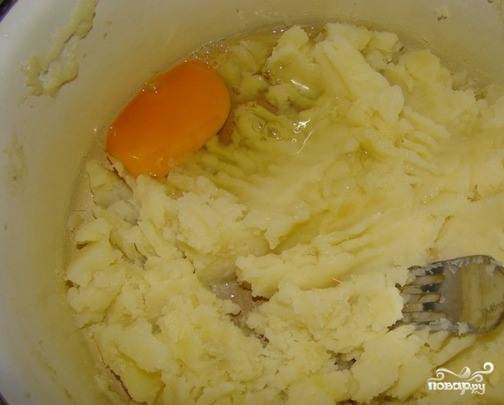 Картофель вымойте, очистите и отварите до полной готовности в подсоленной воде. Превратите его в пюре при помощи толкушки или блендера, когда он остынет. Вбейте сырое куриное яйцо, посолите и поперчите. Хорошенько перемешайте все ингредиенты. 