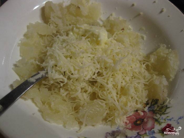 Ввести в картофельную массу тертый сыр (примерно 50% от общего количества), тщательно перемешать. 