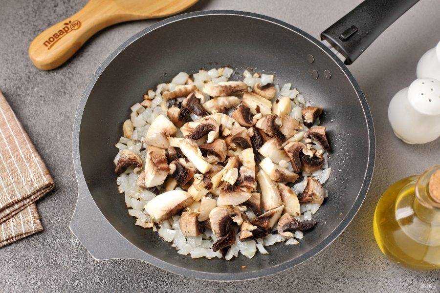 Обжарьте лук до мягкости и добавьте нарезанные грибы.