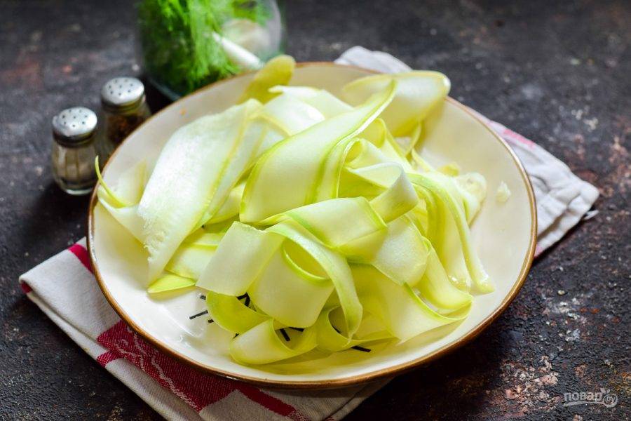 Кабачок сполосните и просушите. Нарежьте кабачок при помощи овощерезки, тонкими пластинами.