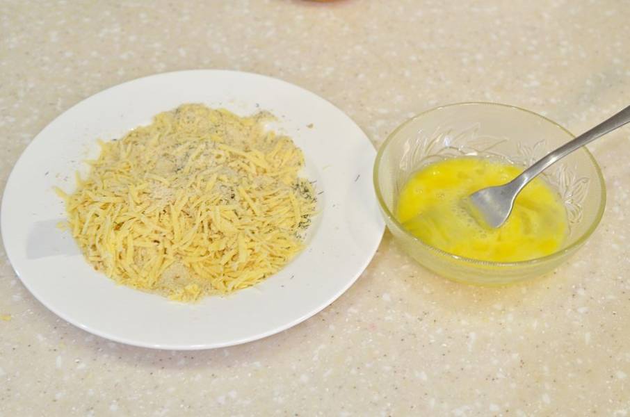 Смешайте в тарелке сухари, сыр и травы. Яйцо в отдельной миске взбейте вилкой.