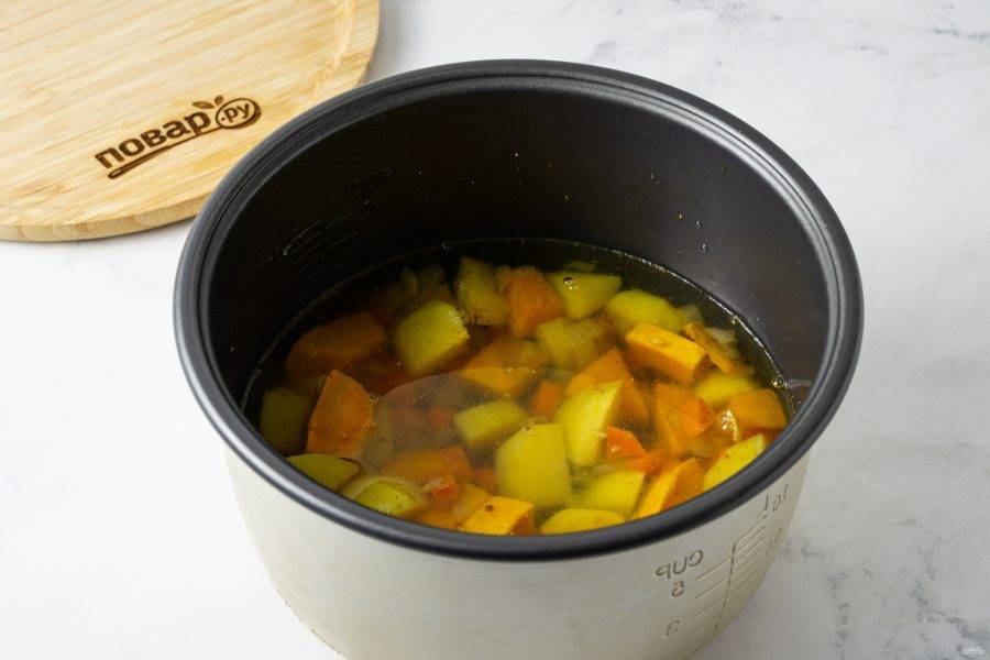 Влейте в чашу воду или бульон, посолите и смените режим на "Тушение". Готовьте суп примерно 30 минут, пока тыква и картофель не станут мягкими.