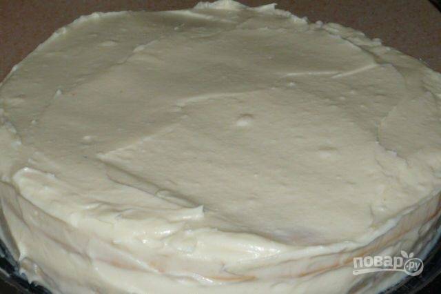 Соберите торт. Укладывайте коржи друг на друга, промазывая их кремом. Торт также смажьте по бокам и сверху.