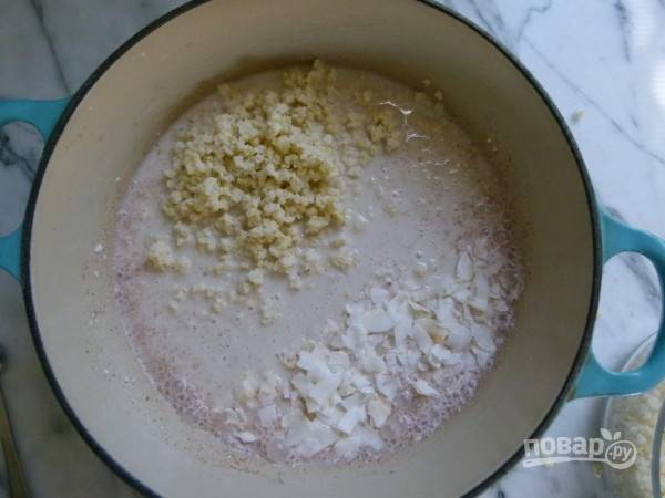 2.	В кастрюлю налейте молоко, добавьте мед, кленовый сироп, экстракт ванили, корицу и 1 чайную ложку хлопьев кокосового ореха, перемешайте и добавьте отварную кашу.