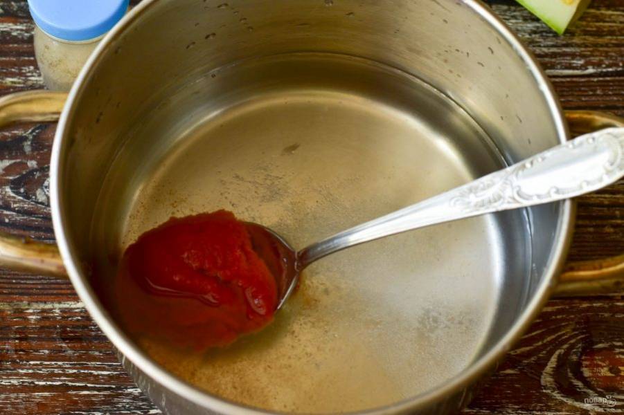 В ковш влейте воду, добавьте соль, сахар и томатную пасту. Влейте растительное масло. Доведите маринад до кипения.