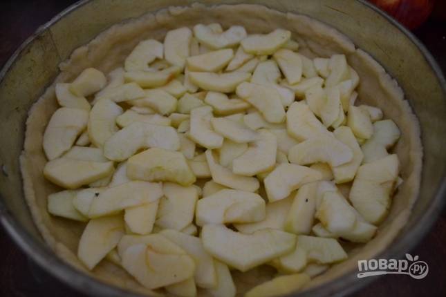 Яблоки чистим от кожуры и нарезаем тонкими дольками. Затем выкладываем их на тесто.