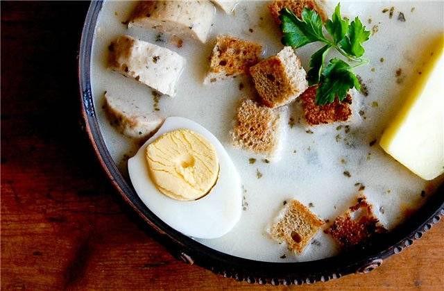 В тарелку выкладываем яйца, колбасу, картофель, зелень и сухарики. Сверху заливаем жидкостью.