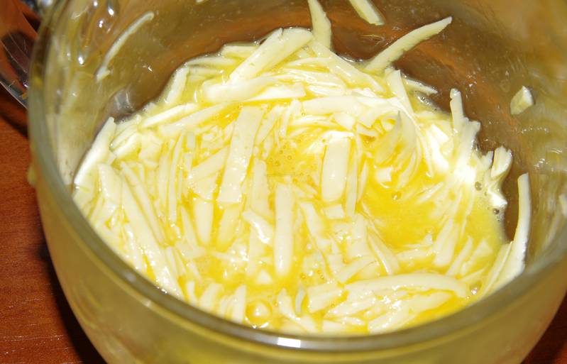 В отдельной ёмкости смешайте яйцо с тертым сыром.