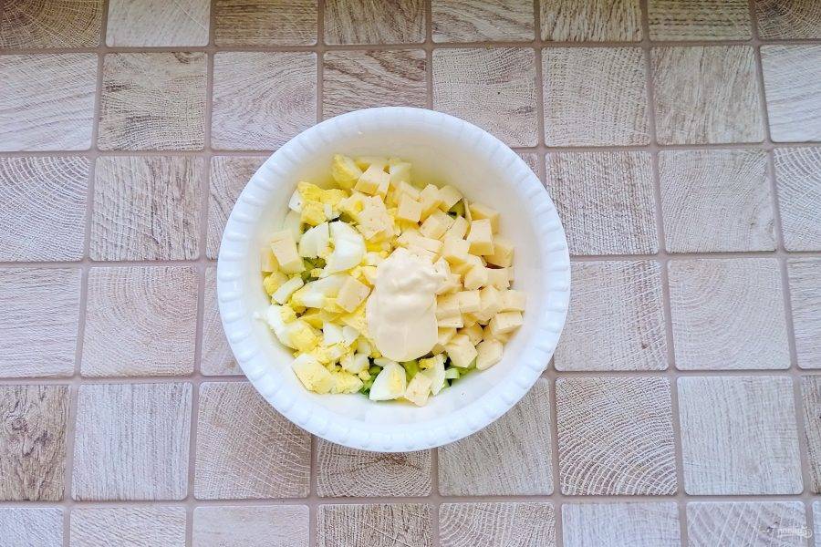 Колбасный сыр нарежьте кубиками и выложите в салат. Заправьте майонезом.