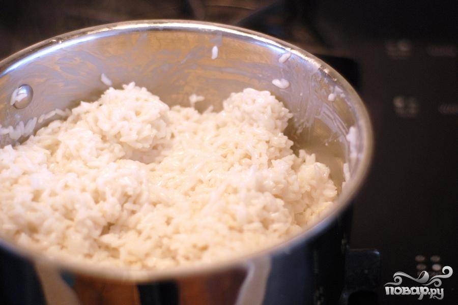 4. Когда рис закипит, уменьшить огонь до среднего уровня. Положить крышку кастрюли наискосок, чтобы выходил пар. Варить 15-20 минут, пока рис не вберет в себя всю (или почти всю) жидкость.