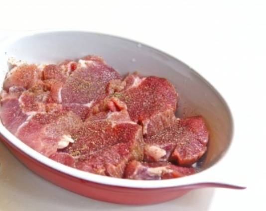 Мясо моем, обсушиваем и нарезаем на куски толщиной примерно 1-1,5 см. Слегка (!) отбиваем, посыпаем солью, перцем и специями. Выкладываем подготовленное мясо в смазанную маслом форму для запекания и оставляем минут на 15-20.
