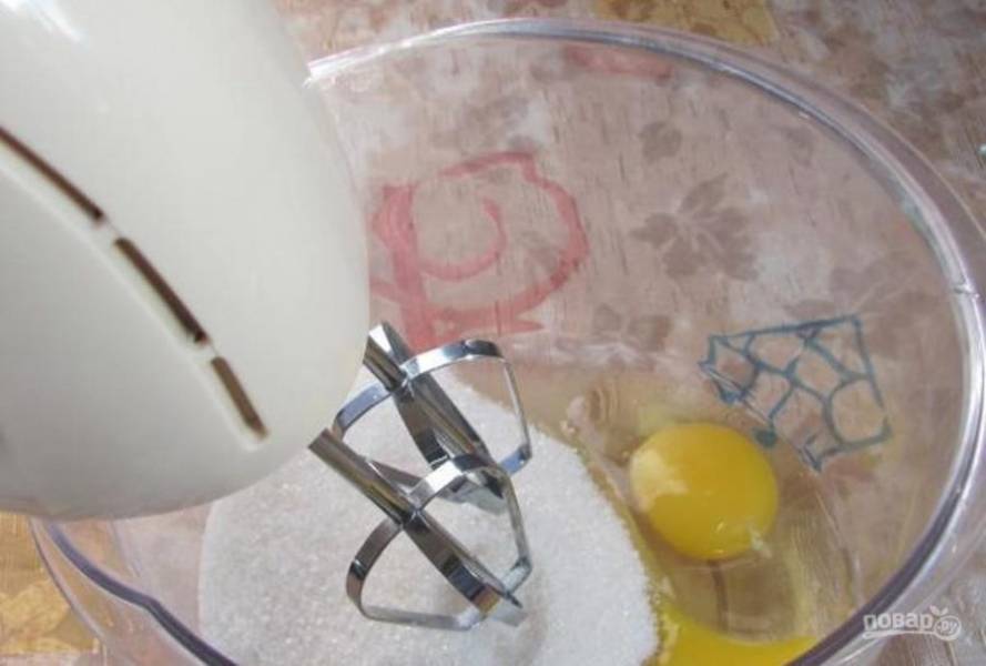 Разотрите сахар с яйцами с помощью миксера.