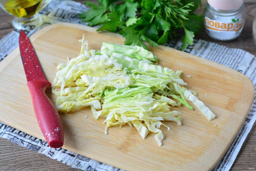 Нашинкуйте белокочанную капусту. Для рецепта можете взять молодую капусту — она сочная и нежная.