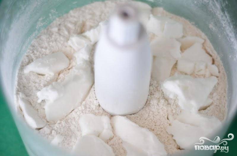 1. Приготовить тесто. Сливочное масло нарезать небольшими кусками. В кухонном комбайне смешать сухие ингредиенты в течение нескольких секунд, затем добавить растительный жир и перемешать, пока смесь не будет выглядеть, как мокрый песок. 
