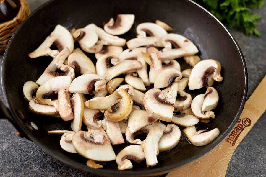 Долейте еще немного масла, выложите нарезанные пластинками грибы, обжарьте до румяной корочки, также снимите на тарелку. 