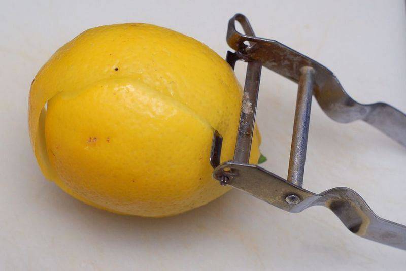 Специальным ножом снимите цедру с лимона. Снимайте только верхний слой, т.к. белый слой будет горчить и испортит наливку.
