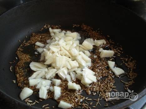 На сухой горячей сковороде поджарим зиру, затем добавим совсем немного растительного масла и чеснок.