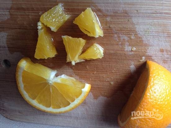 Половину апельсина очистим и нарежем на кусочки, удаляя перепонки. Из оставшегося вдавим сок.