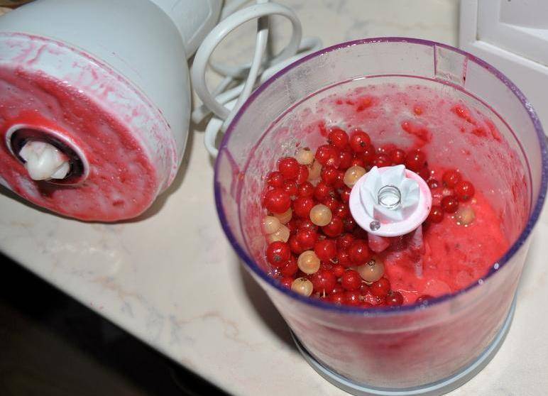 Перетертую ягоду перекладываем в стерилизованную баночку, а в блендер насыпаем новую порцию смородины с сахаром и опять все перемалываем.