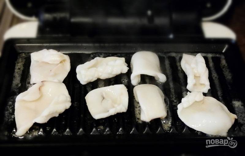 4.	Разогрейте гриль, выложите кальмары, прижмите их и обжаривайте несколько секунд, чтобы получилась красивая решетка.