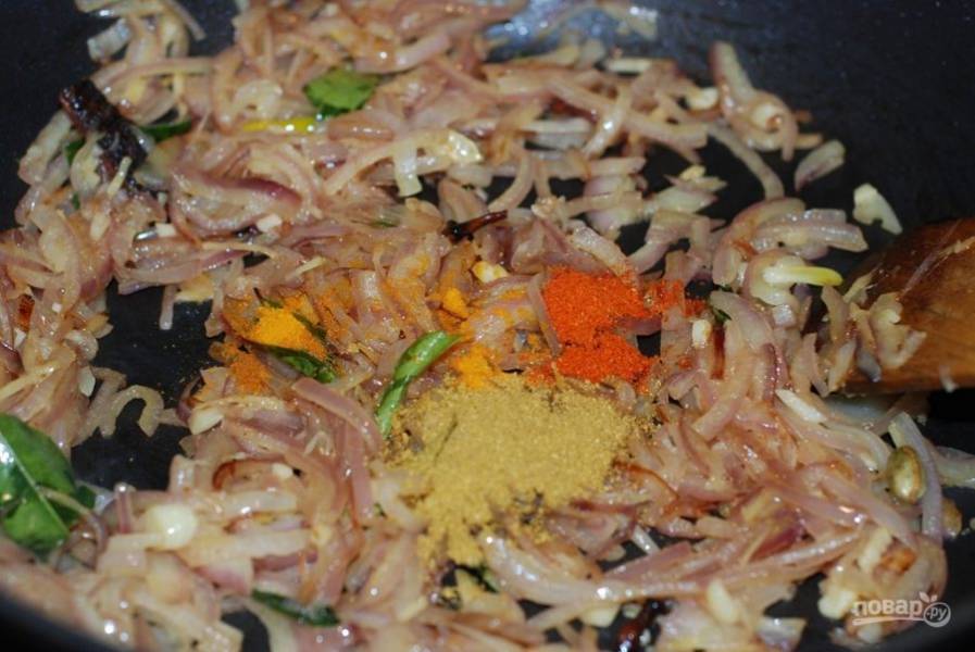 3. Освободите сковородку от рыбы. В нее же добавьте оставшееся специи: черный молотый перец, куркуму, чили. Добавьте нарезанный лук, чеснок. Тушите на медленном огне.