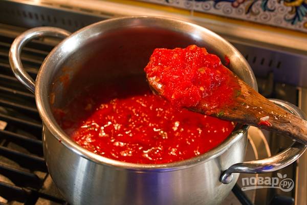 5. Разогрейте в кастрюле растительное масло. Обжарьте лук с чесноком до мягкости, выложите помидоры и половину базилика. Добавьте соль и перец. Томите на среднем огне соус, помешивая, пока он немного не загустеет. 