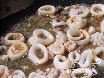 Посолите кальмары и всё перемешайте. Нагрейте оливковое масло в сковороде и поместите туда кальмары. И готовьте не более одной минуты (если кальмары замороженные, для свежих - не более 45 секунд).