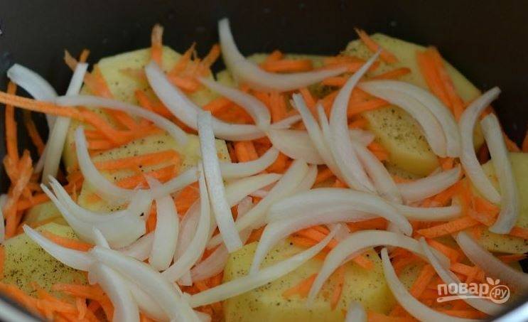 Почистите лук и морковь, вымойте овощи и обсушите. Лук нарежьте полукольцами, а морковку натрите на крупной терке. Выложите овощи на картофель. 