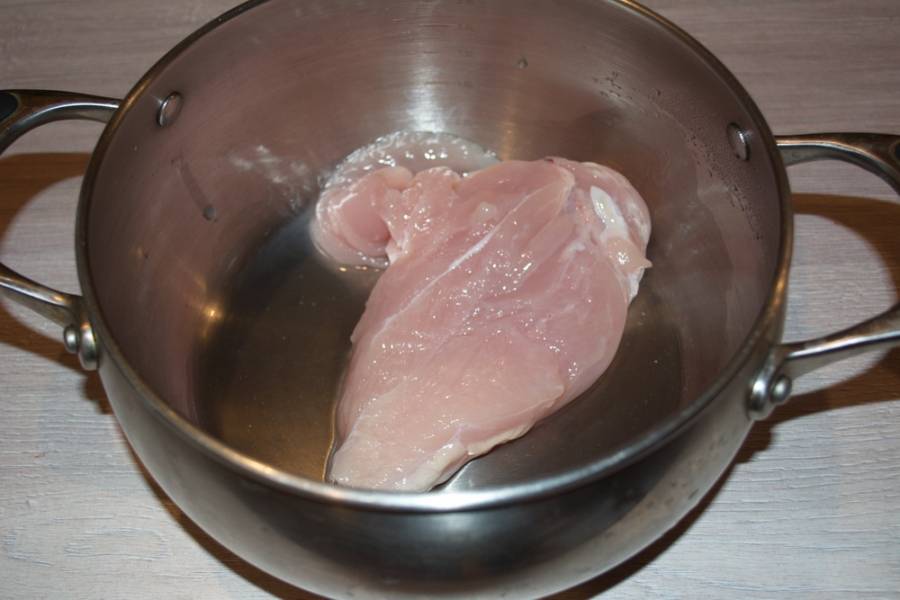 7.  Пока зажарка тушится, в кастрюлю налейте воду, опустите в неё куриное филе. Поставьте вариться. Около 10-15 минут будет достаточно.