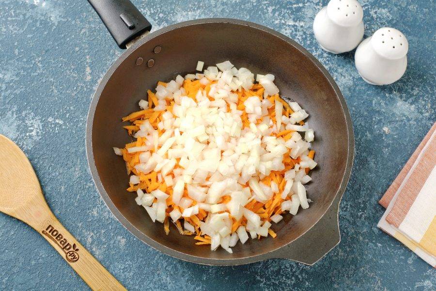 На сковороде разогрейте масло и выложите нарезанный кубиками лук и тёртую морковь. Обжарьте овощи до мягкости.