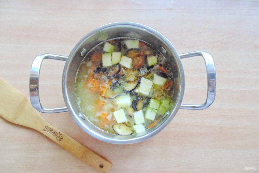 Когда картофель, лук и морковь будут почти готовы, добавьте в кастрюлю баклажаны и нарезанный кабачок.
