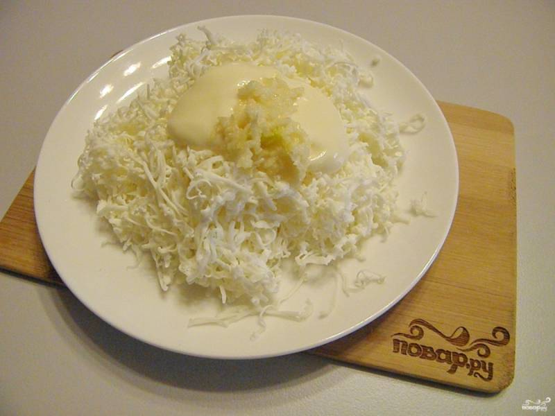 Плавленый сыр натрите на мелкой терке, добавьте к нему майонез и пропущенный через пресс чеснок. Перемешайте хорошенько массу. Солить не нужно, так как сырок уже содержит соль.