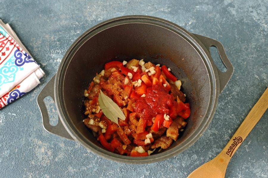 Затем добавьте нарезанный небольшой соломкой болгарский перец, томатную пасту, измельченный чеснок, сахар, лавровый лист, соль и специи по вкусу.