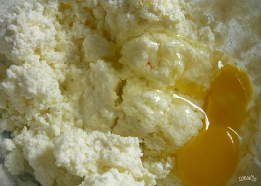 1.	В миску кладу творог, его можно не перетирать. Добавляю 2 куриных яйца и всыпаю сахарный песок, перемешиваю.