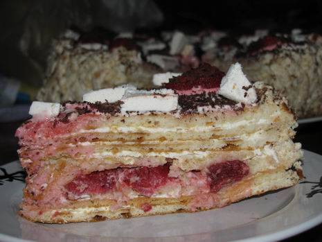 Торт промазать сметанным кремом, в середину положить ягоды. Украсить торт также ягодами и тертым шоколадом. 