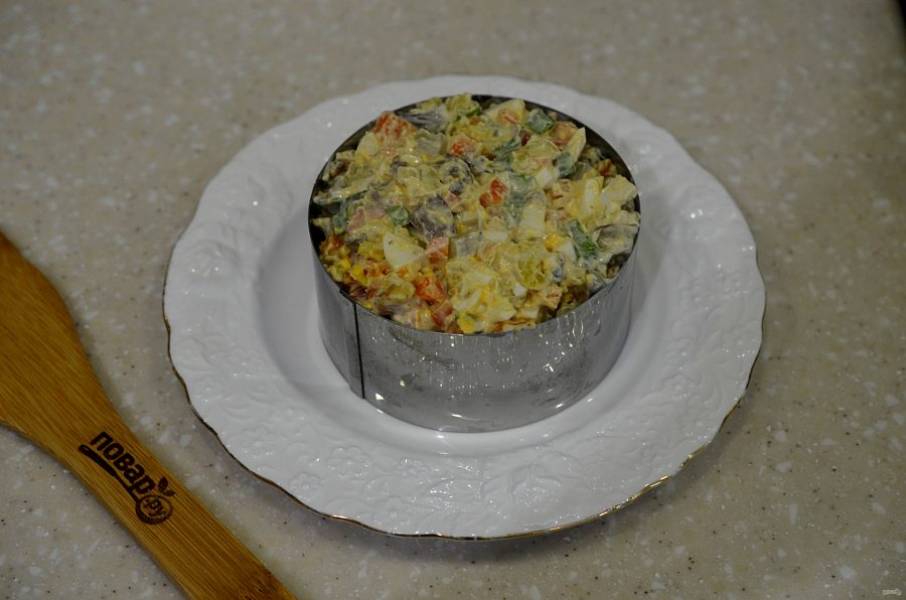 6. Выложите салат в сервировочное кольцо. Кольцо аккуратно уберите и посыпьте сверху тертым сыром.