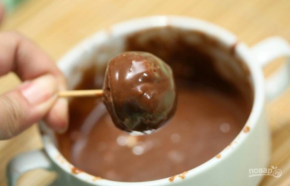 5. Окуните конфеты в растопленный шоколад. Поставьте на пергамент.