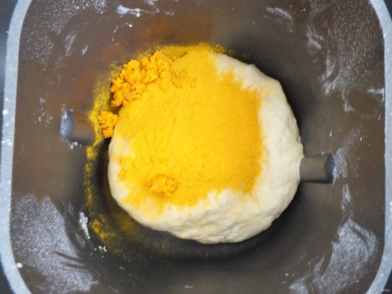 В большую часть теста добавьте апельсиновую цедру, куркуму и замесите однородное тесто с помощью хлебопечки.