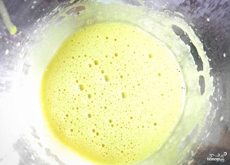 В другой посуде взбейте желтки. А в кастрюльке сварите сахар с водой до загустения. Потом влейте сахарный сироп в желтковую массу, продолжая взбивать.