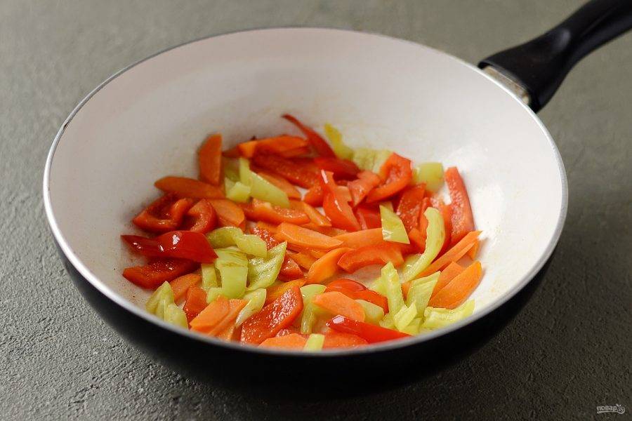 Морковь очистите от кожуры, из перцев удалите семена. Нарежьте овощи ломтиками среднего размера. Обжарьте все овощи, кроме горошка, до мягкости. За минуту до готовности добавьте горошек, перемешайте.
