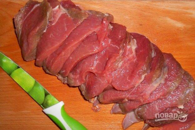 Мясо промойте. Удалите с него прожилки и плёнку. Нарежьте мякоть слайсами.