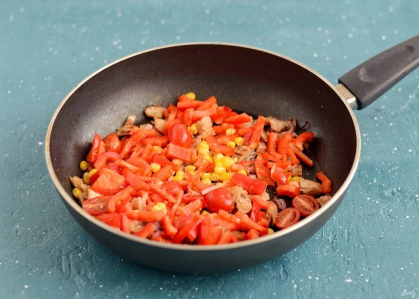 В конце добавьте помидоры, болгарский перец нарезанный на брусочки и кукурузу. Потушите 5 минут, посолите по вкусу. 
