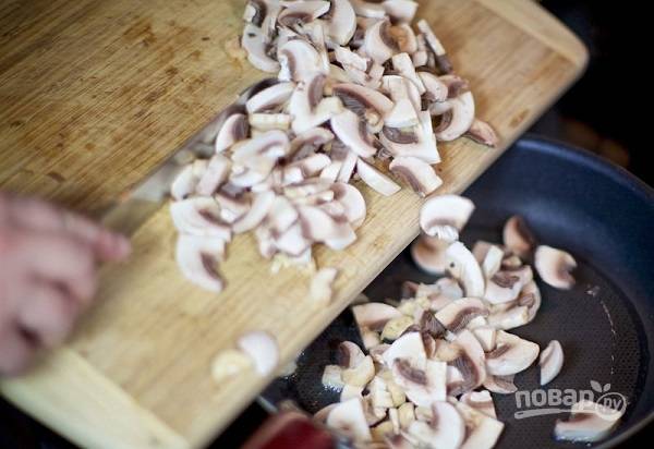 3. Параллельно можно заняться грибами. Вымойте их, обсушите и нарежьте тонкими ломтиками. На сковороде разогрейте немного масла, выложите туда грибы. 