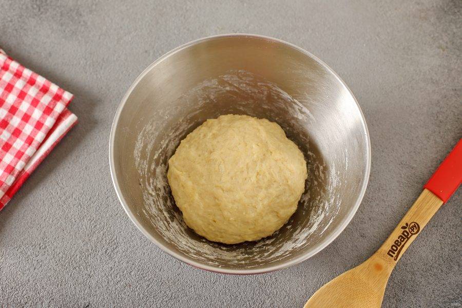 Все перемешайте, а затем руками замесите мягкое, чуть липкое тесто. Соберите его в шар, накройте миску пищевой пленкой и уберите в теплое место на 1-1,5 часа.