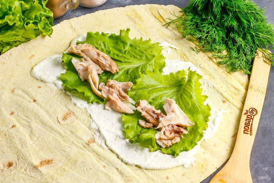 Разберите отварную курицу на части и выложите на листья салата.